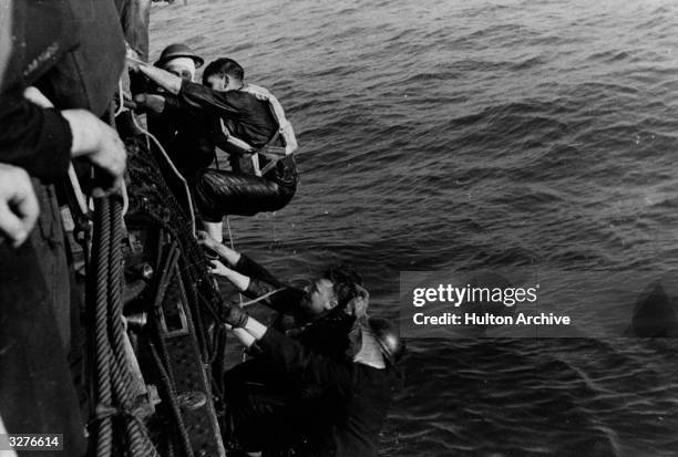 British ship rescues soldiers from a landing craft sunk during an operation.