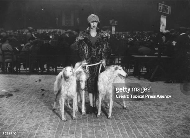Miss Vlasto stands with her Borzoi dogs in the exhibition ring, having entered them in the Crufts Dog Show at the Royal Agricultural Hall in...