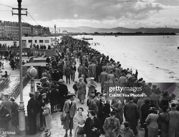 Holidaymakers strolling along the promenade at the seaside town of Rhyl, North Wales.