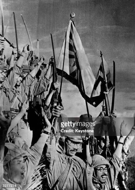 Japanese jubilation, Samurai swords brandished in the air and the flag of the Rising Sun proudly held aloft after the capture of Bataan, Philippine...