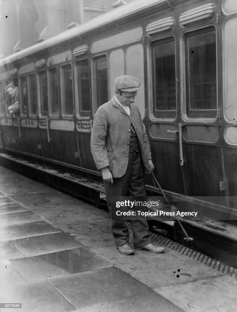 Train Wheeltapper A man tapping the wheels, examining for cracks, on the Great Central ...