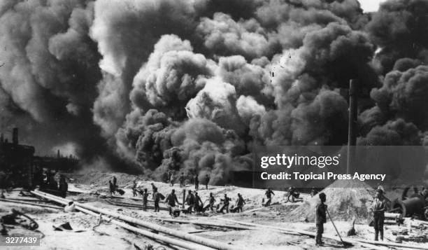 Men working amidst the thick smoke of the Baku oil fields.