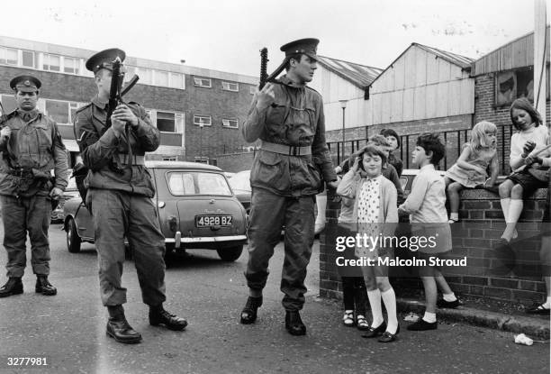 Armed British soldiers impose a curfew on the Falls Road in Belfast.