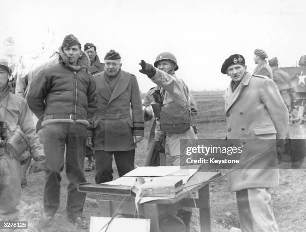 Allied Chiefs Air Marshal Arthur Tedder , General Dwight D Eisenhower , and Field Marshall Bernard L. Montgomery , watch tank manoeuvres in...