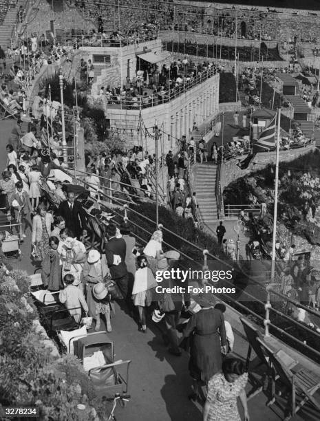 Holidaymakers enjoying the sunshine at Tinside, Plymouth Hoe in Devon.