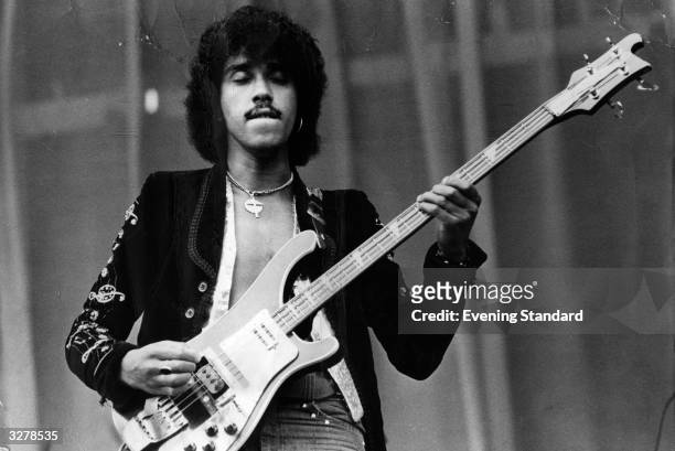 Phil Lynott , singer and bass guitarist with the rock group Thin Lizzy, performs on stage.