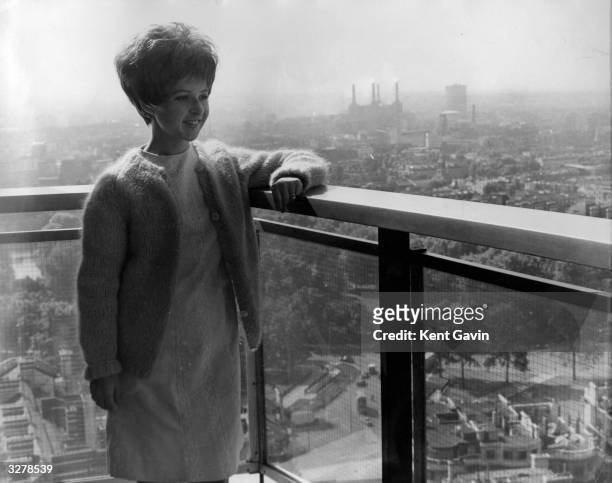 American pop star Brenda Lee admires the view from her Hilton Hotel apartment during a trip to London for recording and TV appearances. Battersea...