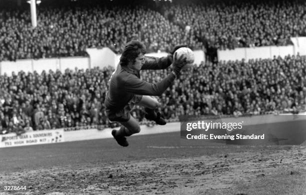 Ray Clemence, the goalie for Liverpool catches the ball in mid air.