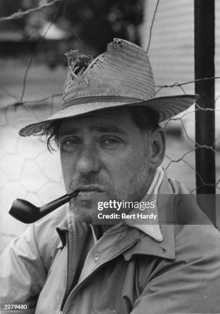 British photographer, Bert Hardy , smokes a pipe while on an assignment in southern Africa. Original Publication: Picture Post - 5024 - Rights And...