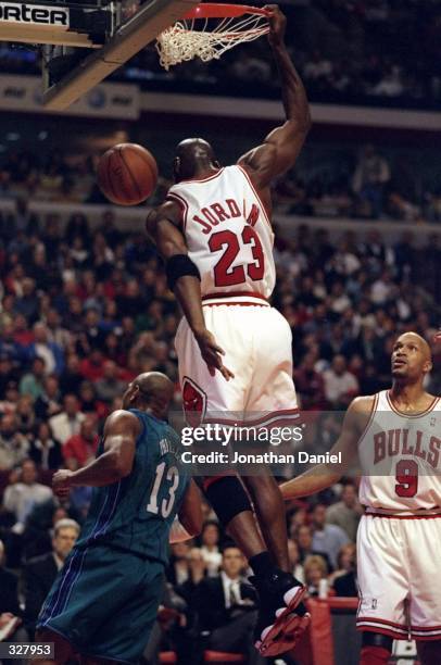 Michael Jordan and Ron Harper of the Chicago Bulls in action against Bobby Philis of the Charlotte Hornets during the NBA Playoffs round 1 game at...