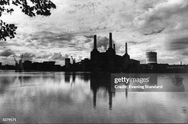 The gothic-style towers of Battersea Power Station, designed by leading architect Giles Scott, on the bank of the river Thames.