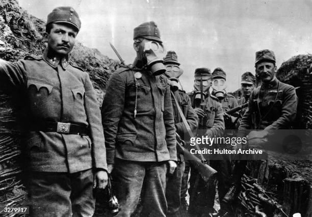 Austrian soldiers in the trenches demonstrating their gas masks.