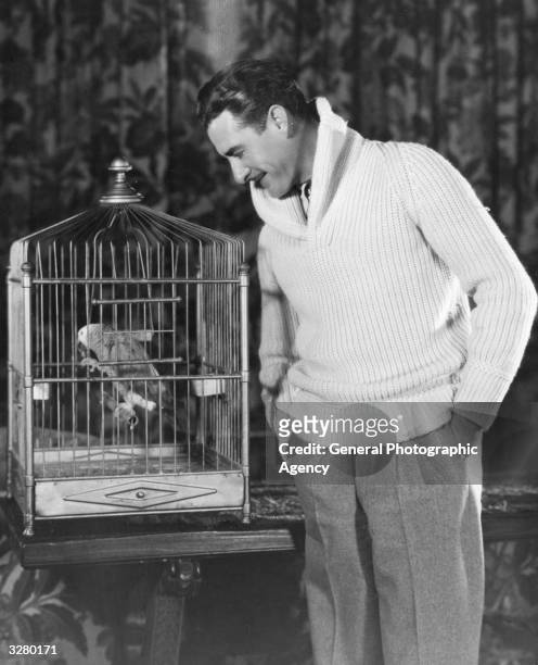John Gilbert , the US film star with his pet parrot.