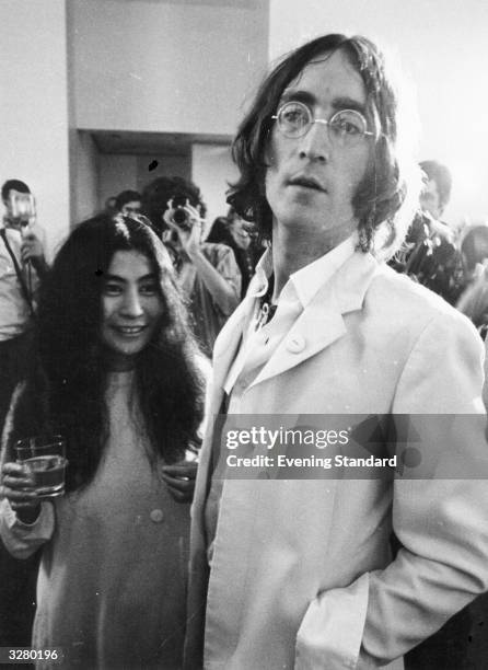 Rock singer, songwriter and guitarist John Lennon and his partner, Japanese-born artist Yoko Ono, at a reception.