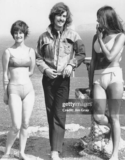 George Harrison of pop group the Beatles talks to 17 year old Catherine Osbourne of Stanstead Abbots, Hertfordshire, and her friend who are on...