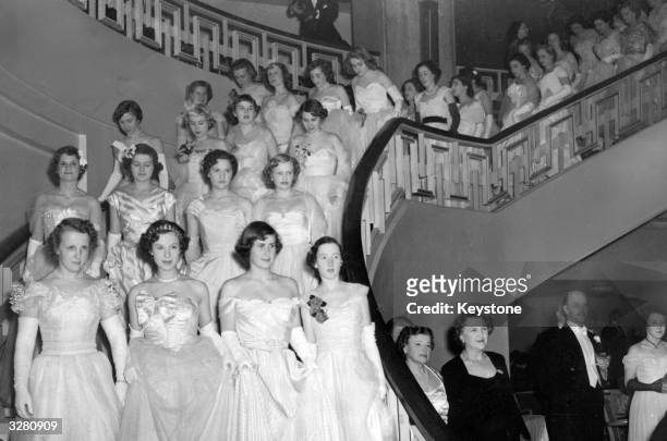 The massed ranks of debutantes at the Queen Charlotte's Ball at Grosvenor House descend into the ballroom.