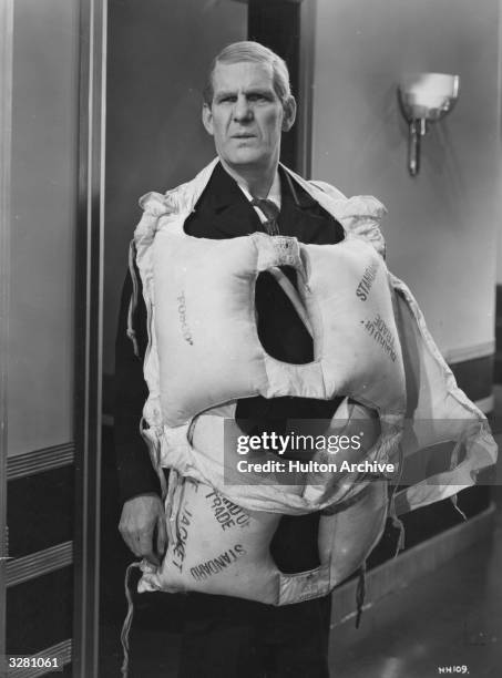 British comic actor Will Hay looking typically bemused in a scene from the film 'Hey! Hey! USA', directed by Marcel Varnel for Gainsborough/Gaumont...
