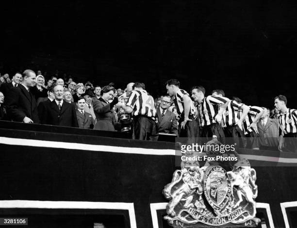 The Queen presents the FA Cup to the Captain of the winning Newcastle United side after their 3-1 victory over Manchester City at Wembley. The Duke...