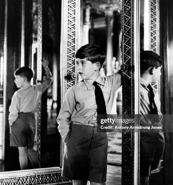 Prince Charles in one of the State Rooms at Buckingham Palace on his eighth birthday.