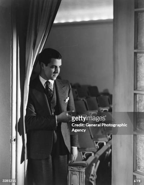 Ramon Novarro , Hollywood film star and actor, signed by MGM, directs guests into his own private cinema.