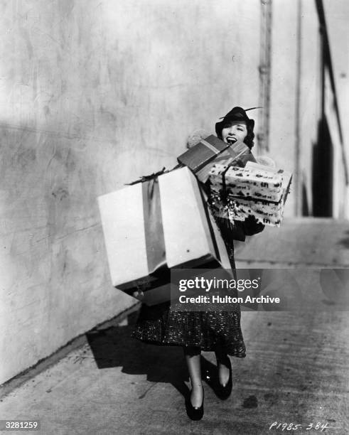 Marsha Hunt, American leading lady, burdened with Christmas presents.