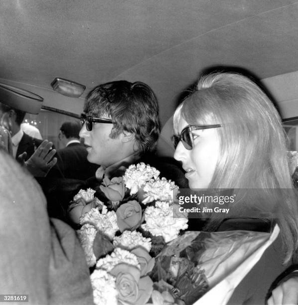 Beatle John Lennon and his wife Cynthia leaving London Airport in a car, having returned from the Beatles' Australian tour.