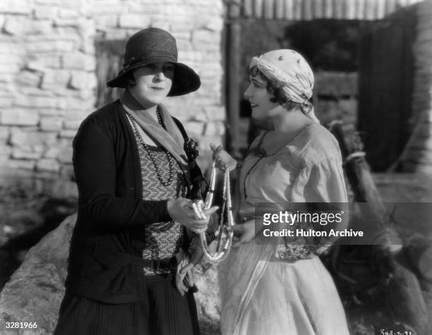 Renee Adoree poses with journalist and photographer Margaret Chute on the set of the MGM film 'The Cossacks', directed by George W Hill and Clarence...