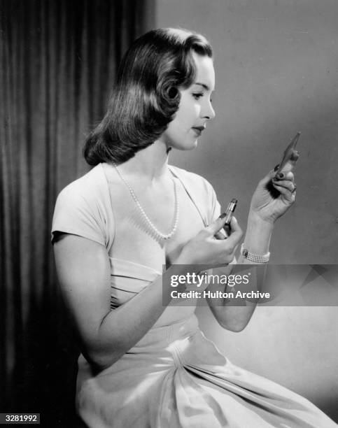 Patricia Roc , the stage name of Felicia Riese, the British leading lady of the 40's with some stage experience. She is applying lipstick and looking...