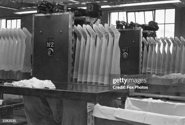 Shaping or 'preboarding' nylon stockings on wooden formers during manufacture.