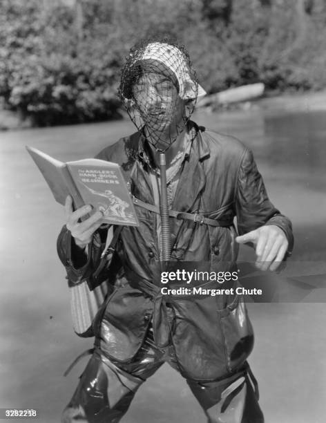 William Powell is in some difficulty on a fishing trip, with an instruction book in one hand he has managed to get a fishing net over his head. Jean...