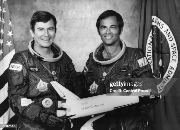 The prime crew commander, John Young and the pilot, Robert Crippen, with a model of the Space Shuttle orbiter Columbia.