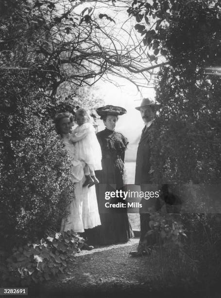 British statesman David Lloyd George , stands among the trees with his first wife Margaret and daughters Mair and Megan.