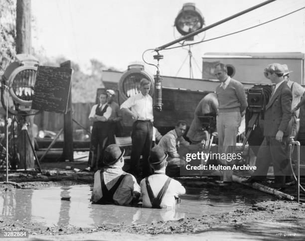 Stan Laurel the stage name of Arthur Stanley Jefferson, the British born comedian and Oliver Hardy the portly American comedian are seated in a...