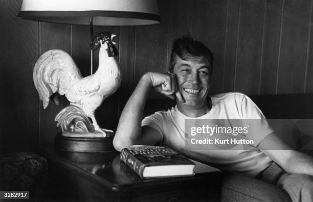 Film director John Huston leaning beside a china lamp in the shape of a cock. Original Publication: Picture Post - 5298 - We Go To Hollywood - pub....