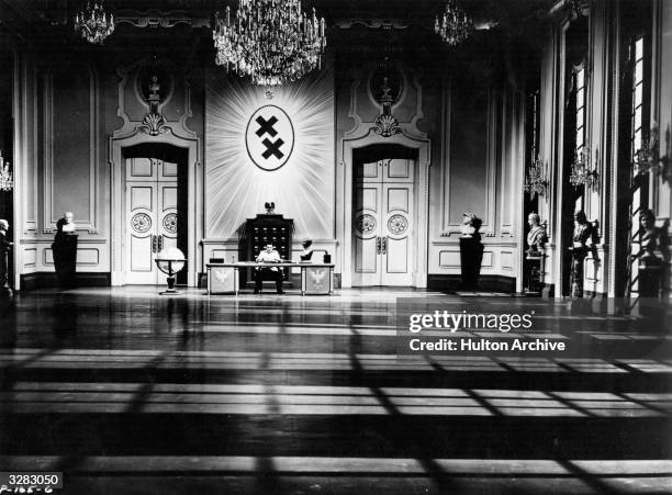 Charles Chaplin sits alone in his headquarters in a scene from the United Artists film 'The Great Dictator', a comedy of mistaken identity directed...