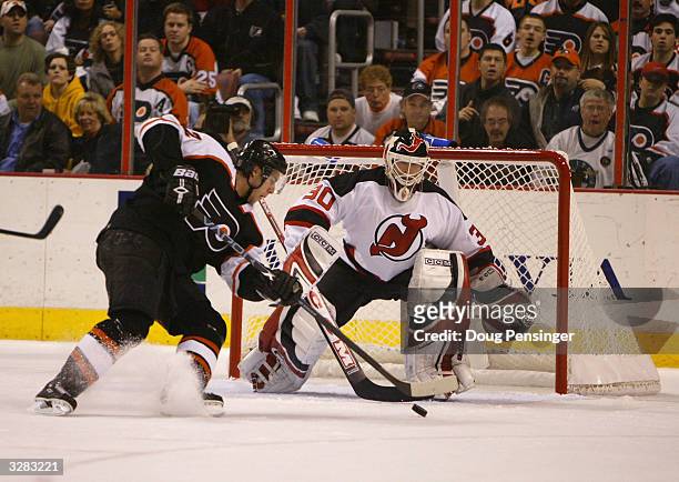 Simon Gagne of the Philadelphia Flyers backhands a shot past goalie Martin Brodeur of the New Jersey Devils to give the Flyers a 1-0 first period...