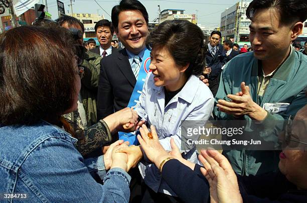 Park Geun-Hye , the main opposition Grand National Party leader and daughter of assassinated former president Park Chung-Hee, shakes hands with...