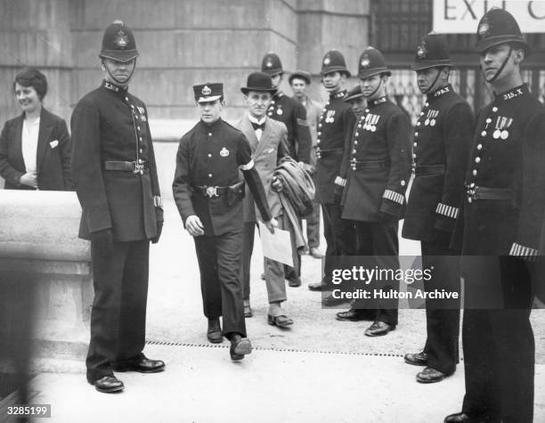 At the opening of the British Empire Exhibition at Wembley, Henry Annals, flanked by police, takes the King's message to the Empire after it had been...