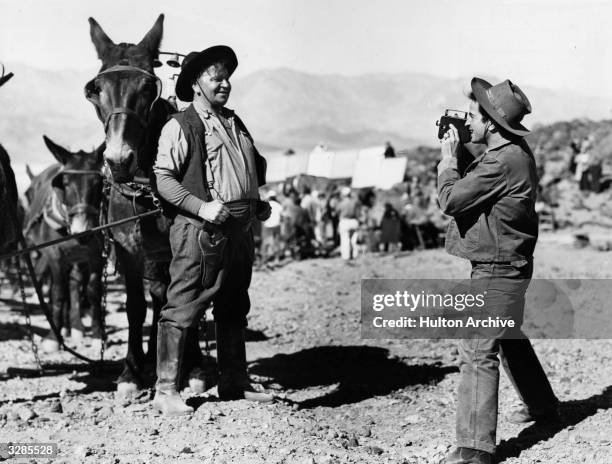 Wallace Beery and his nephew, Noah Beery take turns snapping each other while on location in Death Valley for three weeks during the filming of '20...