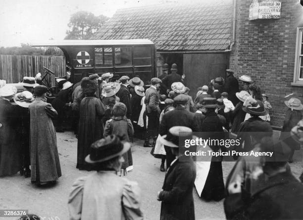 Dead aviators Hamilton and Stuart are taken by Army Motor ambulance to the mortuary at Hitchin after an air accident, while the crowd looks on.