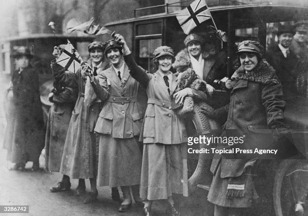 Women of the Women's Royal Australian Naval Service, , waving flags on Armistice Day in London, 11th November 1918.