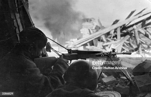 Soviet machinegunners fire at Nazis who had barricaded themselves into houses during street fighting on the outskirts of Stalingrad.