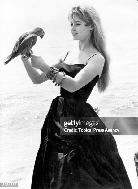 French actress Brigitte Bardot poses with a parrot during the 9th Cannes film festival, France, 23rd April-10th May 1956.