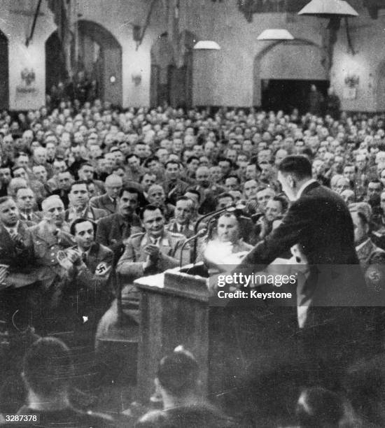 Goering and Goebbels applauding in the front row during a speech by Adolf Hitler in a Munich beer cellar on the anniversary of the German 'shame' of...