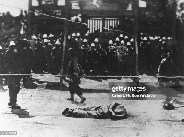 Chinese rebel is beheaded in front of European troops during the Boxer Rebellion.