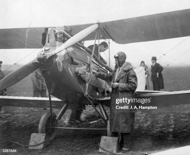 Famous Egyptian explorer, Sir Ahmed Hassanein Bey, fixes a spare propeller to the side of his airplane, before setting off on a solo flight from...