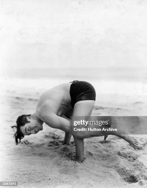 John Boles, the Hollywood actor, doing antics on the beach near his Malibu home.