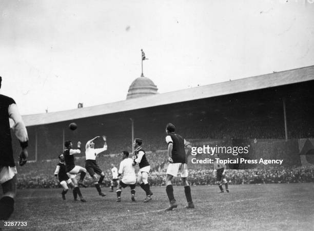 Players leap for the ball during the FA Cup Final between Bolton Wanderers and West Ham United, the first held at the newly completed Wembley...