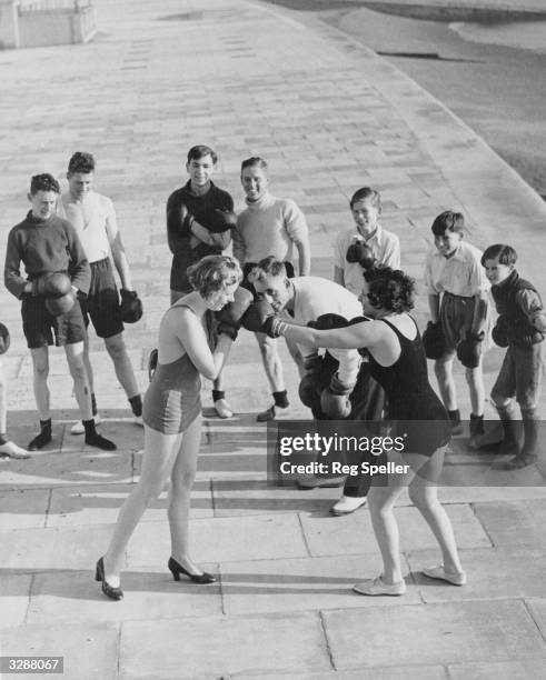 Two female members of a keep fit group learn boxing techniques as part of self defence lessons.