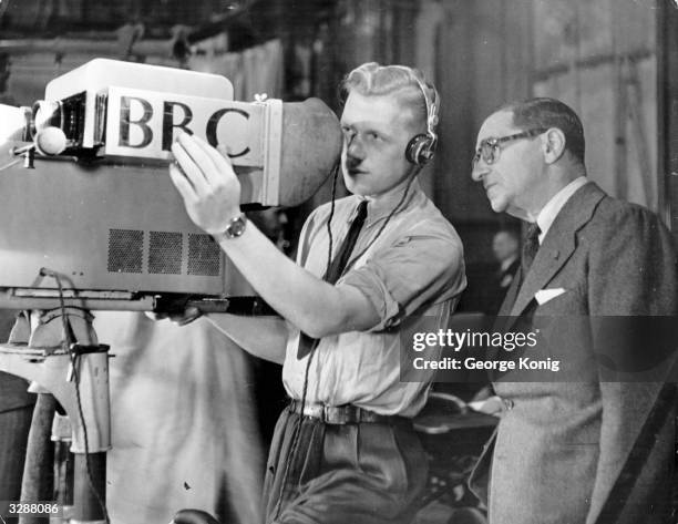 Cameraman explains the technicalities of the television camera to Russian-born US composer Irving Berlin , before the broadcasting of a programme...
